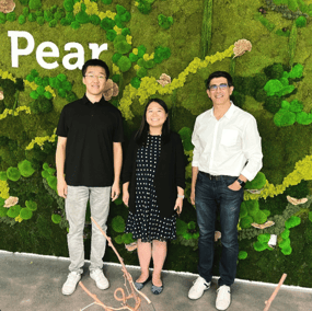 Orby AI co-founders pose with Pear VC investor against a green wall